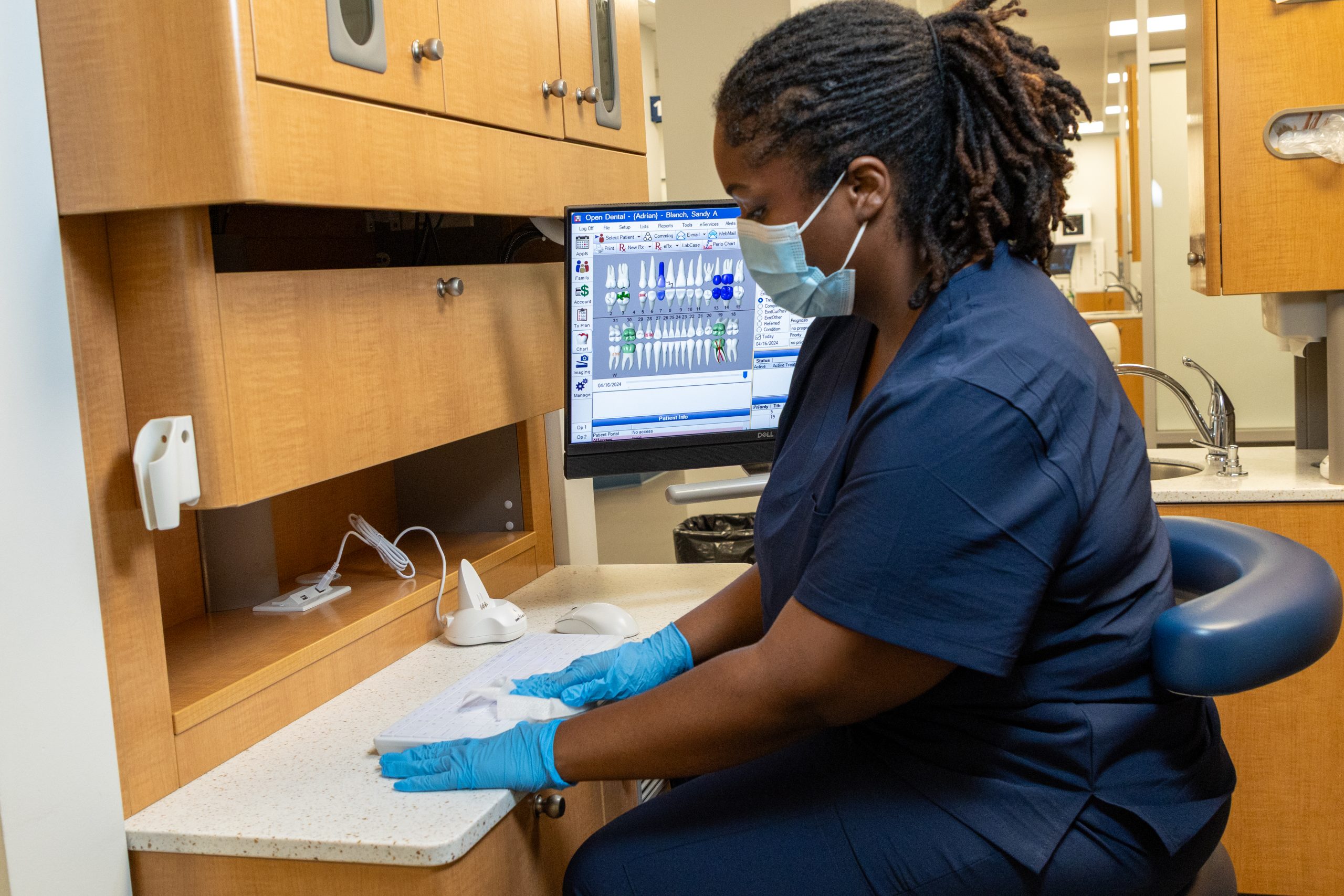 Dental hygienist wiping off washable keyboard.